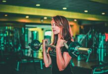 근력 운동이 체중 감량에 미치는 긍정적 영향 woman lifting black and gray barbell