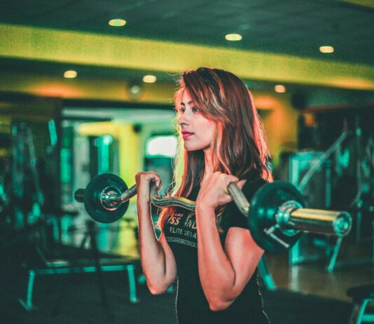 근력 운동이 체중 감량에 미치는 긍정적 영향 woman lifting black and gray barbell