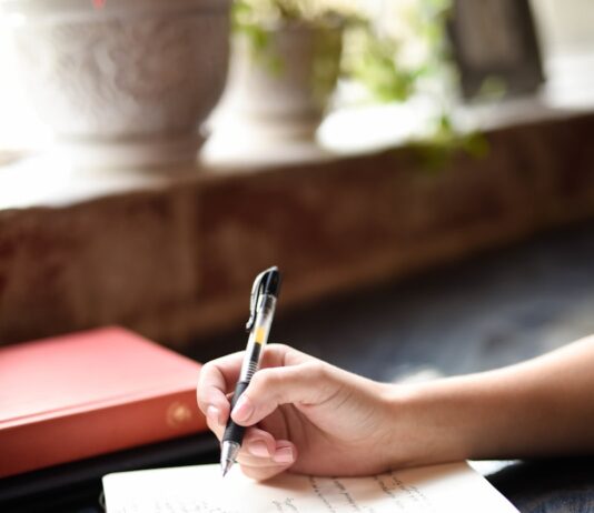 건강한 취미가 주는 행복 a person writing on a piece of paper with a pen