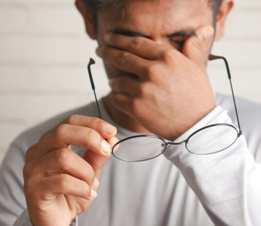 현대인의 눈 건강: 디지털 시대에 필요한 관리법 a man holding a pair of glasses up to his face