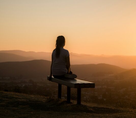 간단하지만 건강한 걷기운동 woman sitting on bench over viewing mountain
