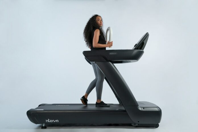 Photo by Intenza Fitness a woman is walking on a treadmill
