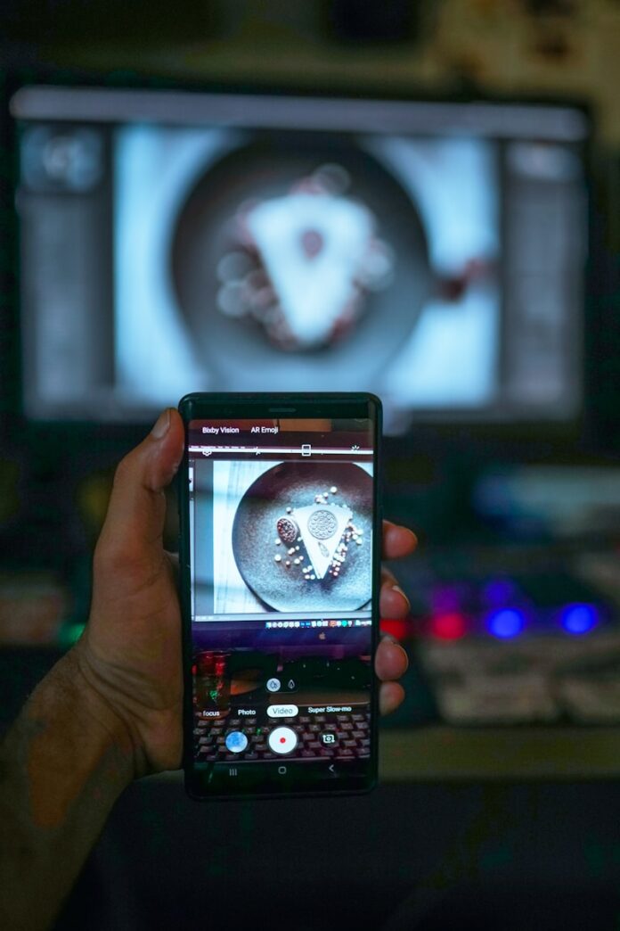 a person holding a cell phone in front of a tv