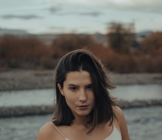 “생리 전에 너무 예민해져요”… 단순한 기분 탓이 아닌 ‘PMS’의 신호 woman in white tank top standing near body of water during daytime