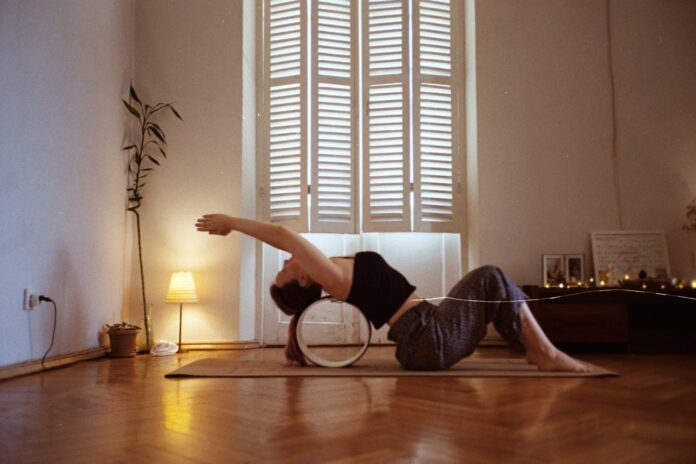 A woman is doing a yoga pose on a mat