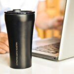 “마시고 채우고, 속도내라”… 현대인 수분 관리 트렌드와 실천법 a black coffee cup sitting next to a laptop