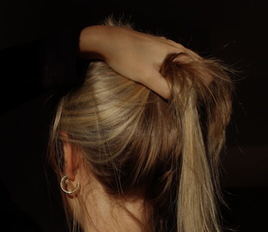 두피를 위한 ‘슬로우 뷰티’ 열풍…건강한 헤어 관리의 일상화 a woman with her hair in a bun