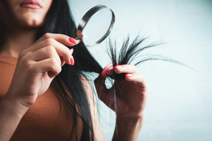 Photo by Sasun Bughdaryan Woman examining split ends of hair with magnifying glass