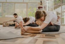 직장인에게 인기 급상승, 필라테스가 바꿔놓는 일상 건강 습관 a group of people doing yoga in a room