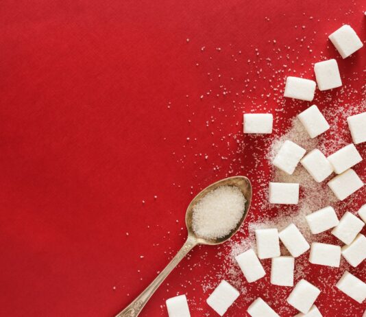 “혈당 스파이크 잡는 법: 건강하고 맛있는 생활습관 팁” sugar cubes and a spoon on a red surface